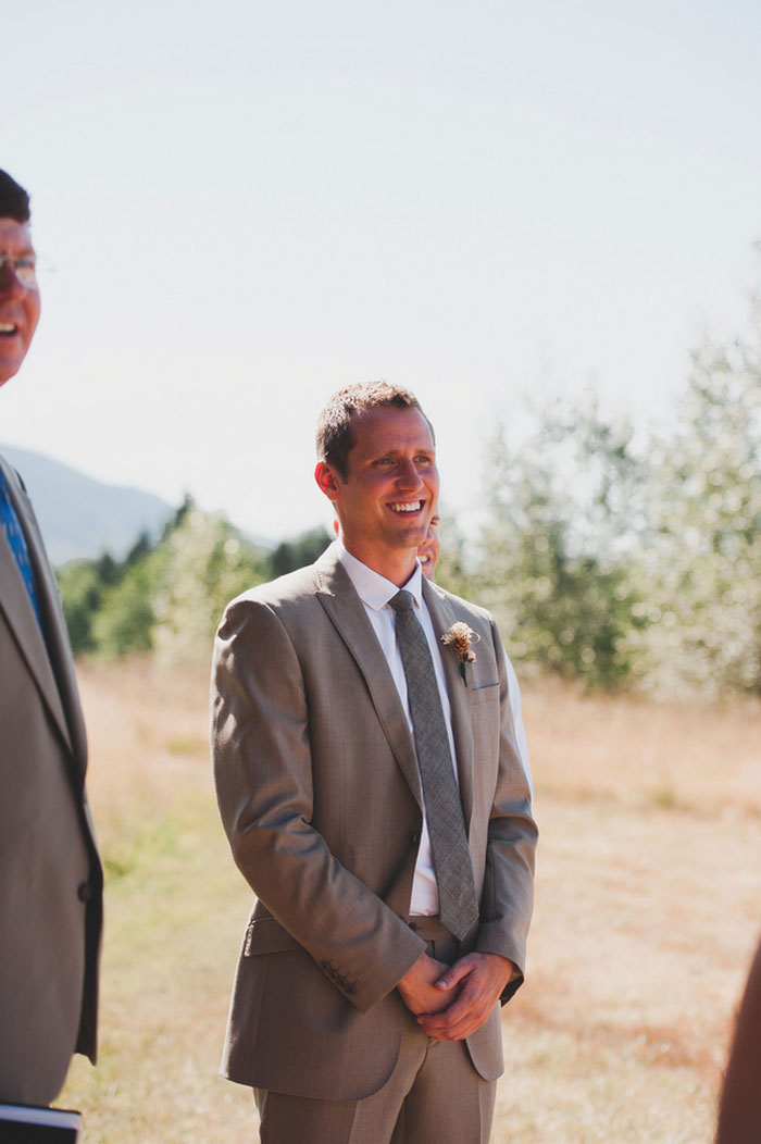 groom watching his bride walk down the aisle