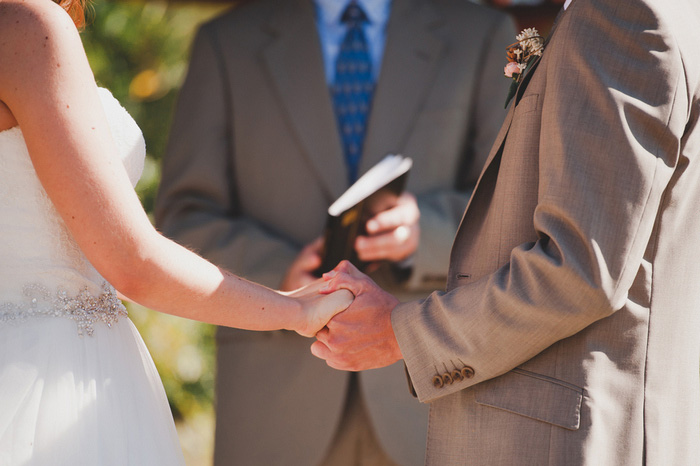 bride and groom holding hands during ceremony