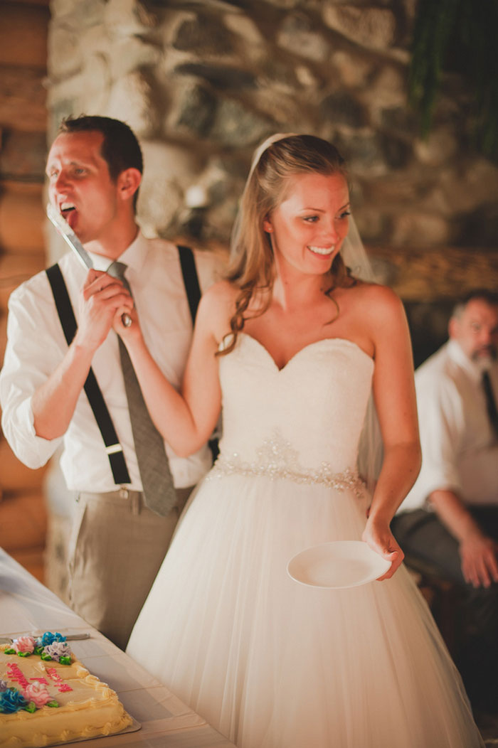 groom licking the cake cutting knife