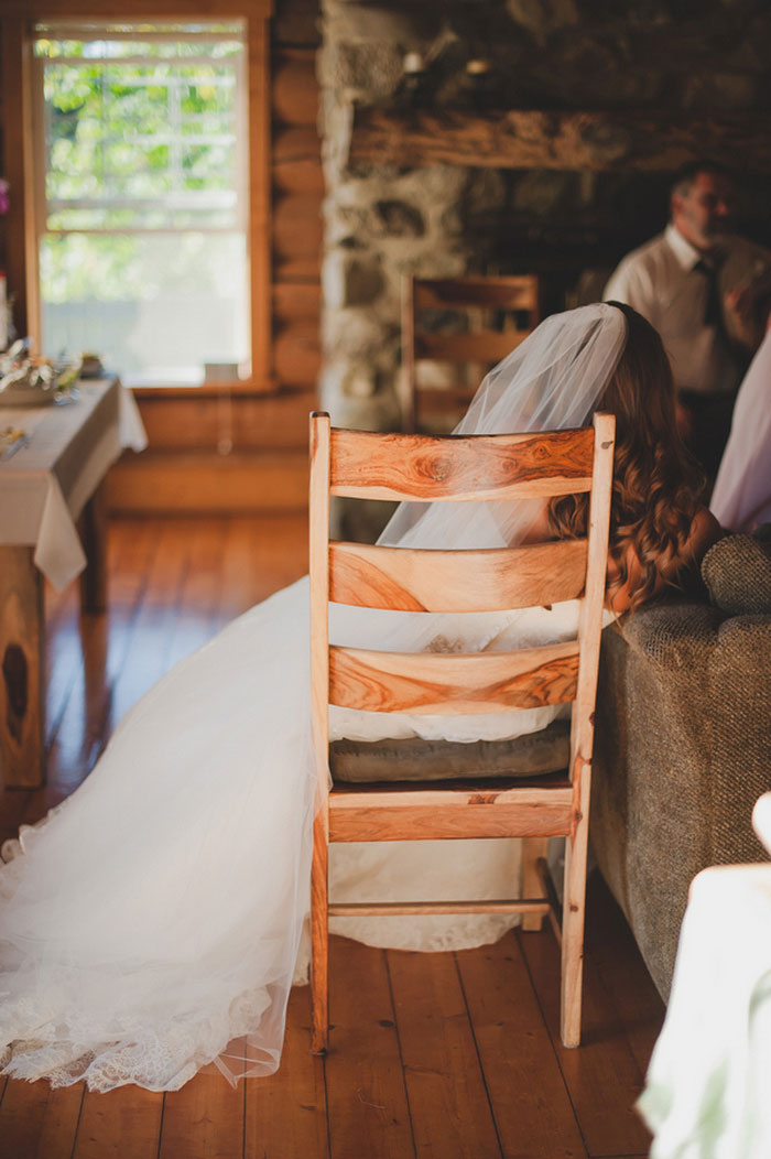 bride sitting on wooden chair in cabin