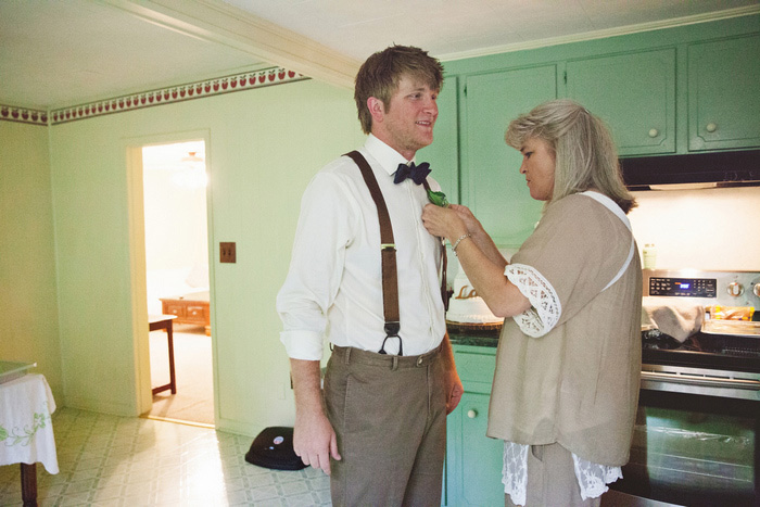 mother of the groom pinning boutonniere on groom