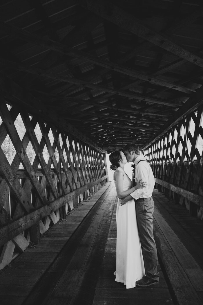 bride and groom portrait on covered bridge
