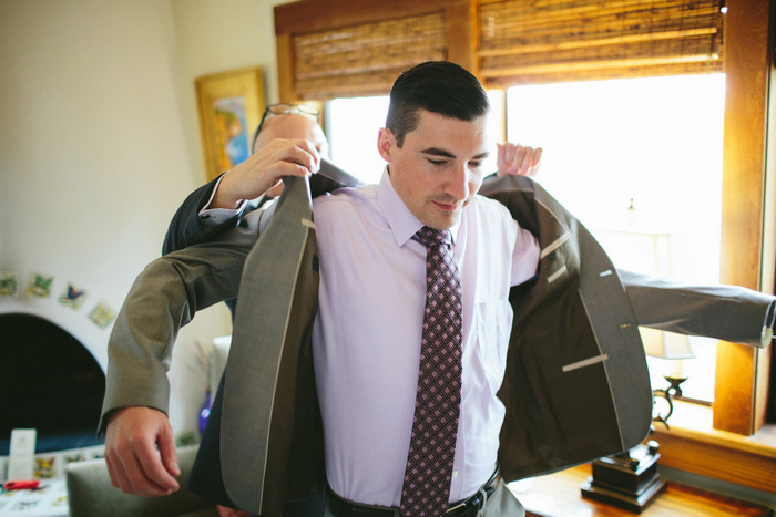 groom putting his jacket on