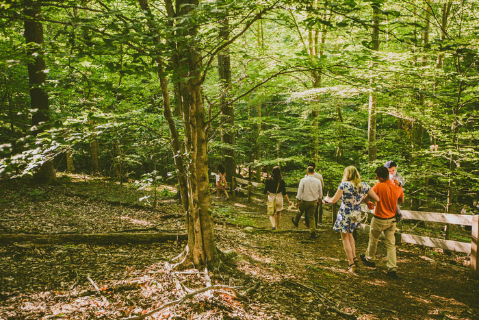 wedding guests walking to ceremony site in the woods