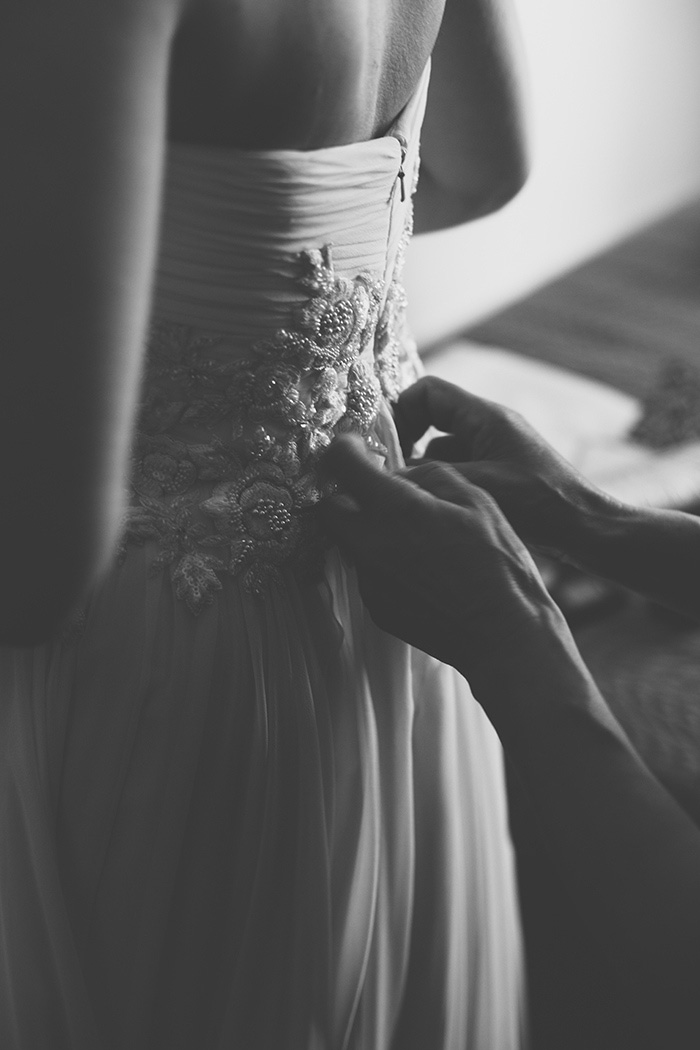 bride getting her dress buttoned