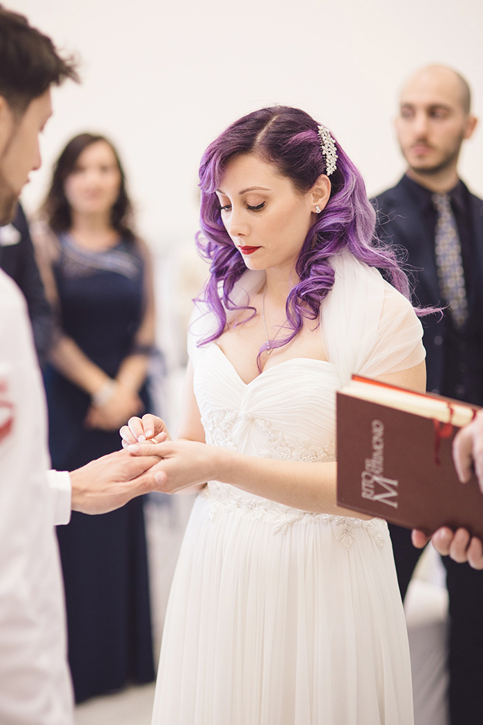 bride putting ring on groom's finger