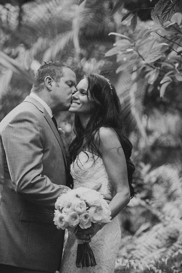 groom kissing bride on cheek