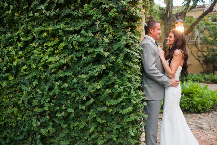 bride and groom portrait against ivy wall