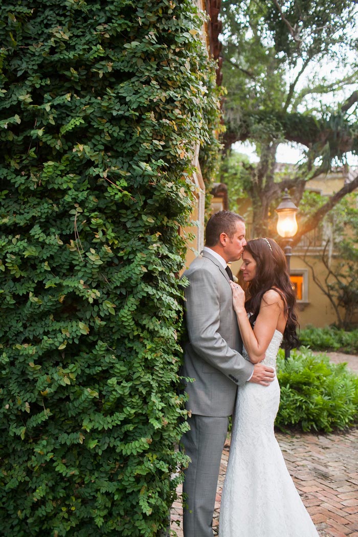 bride and groom portrait against ivy wall