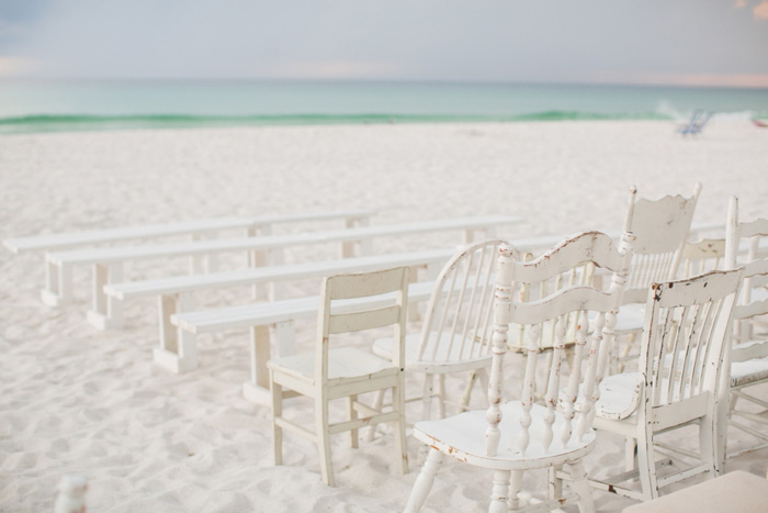 white chairs set up on beach for ceremony