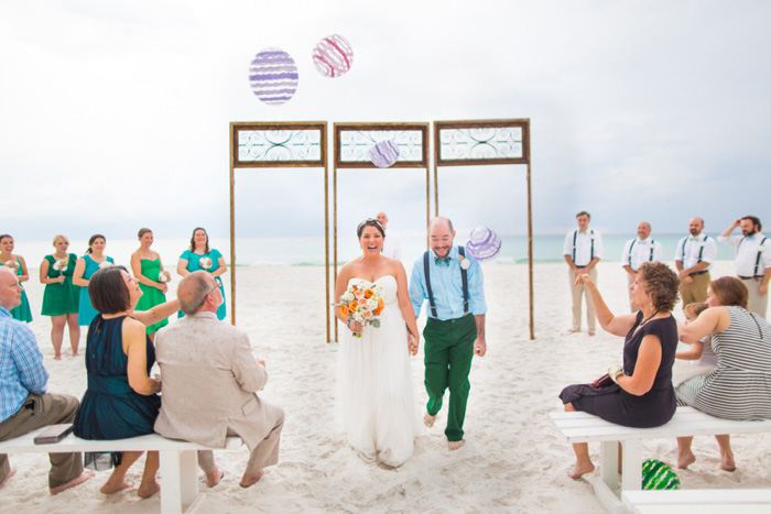 guests throwing beach balls at bride and groom at end of ceremony