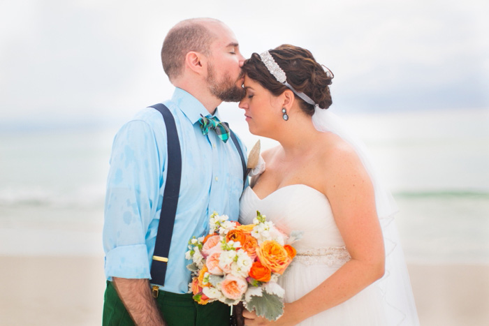 groom kissing bride on then forehead