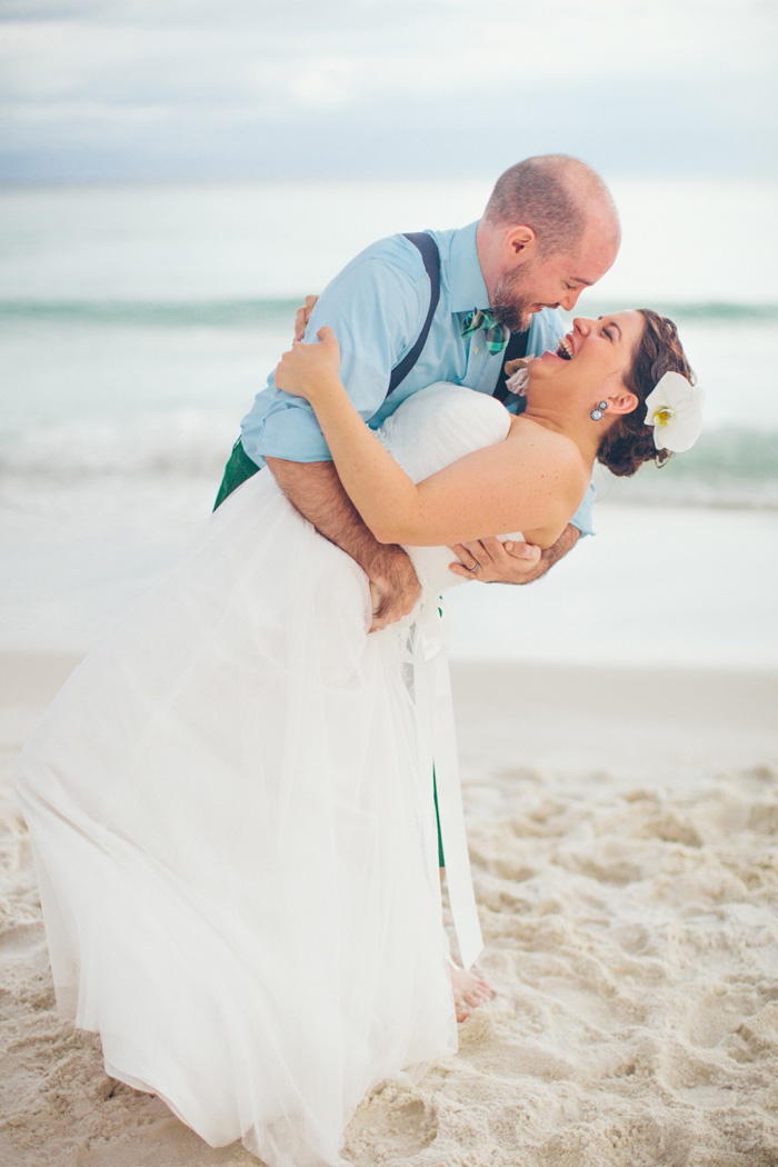 groom dipping bride on the beach