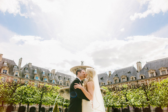 bride and groom kissing in front of fountain