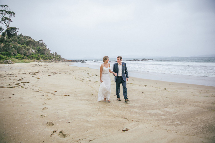 bride and groom walking on the beach