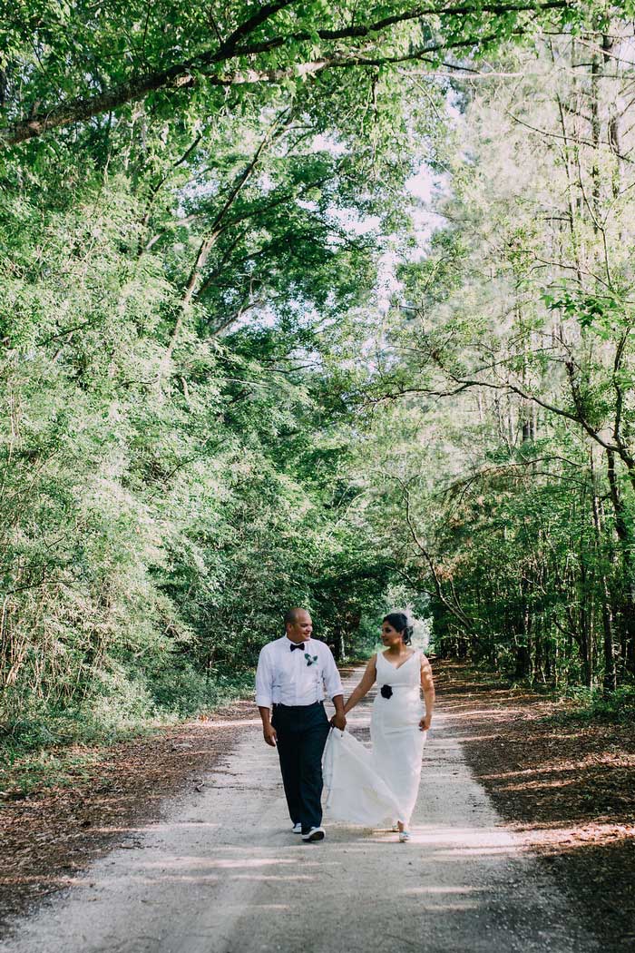 bride and groom walking down dirt road