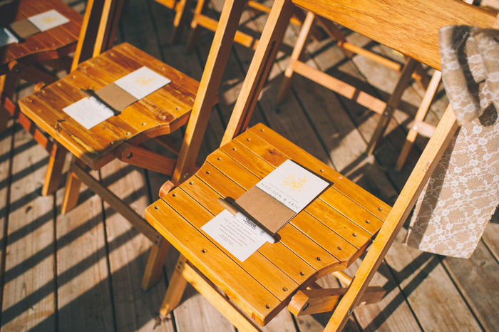 wedding programs on wooden chairs