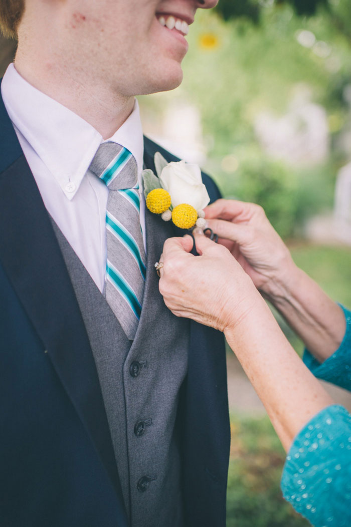 groom getting boutonniere pinned on