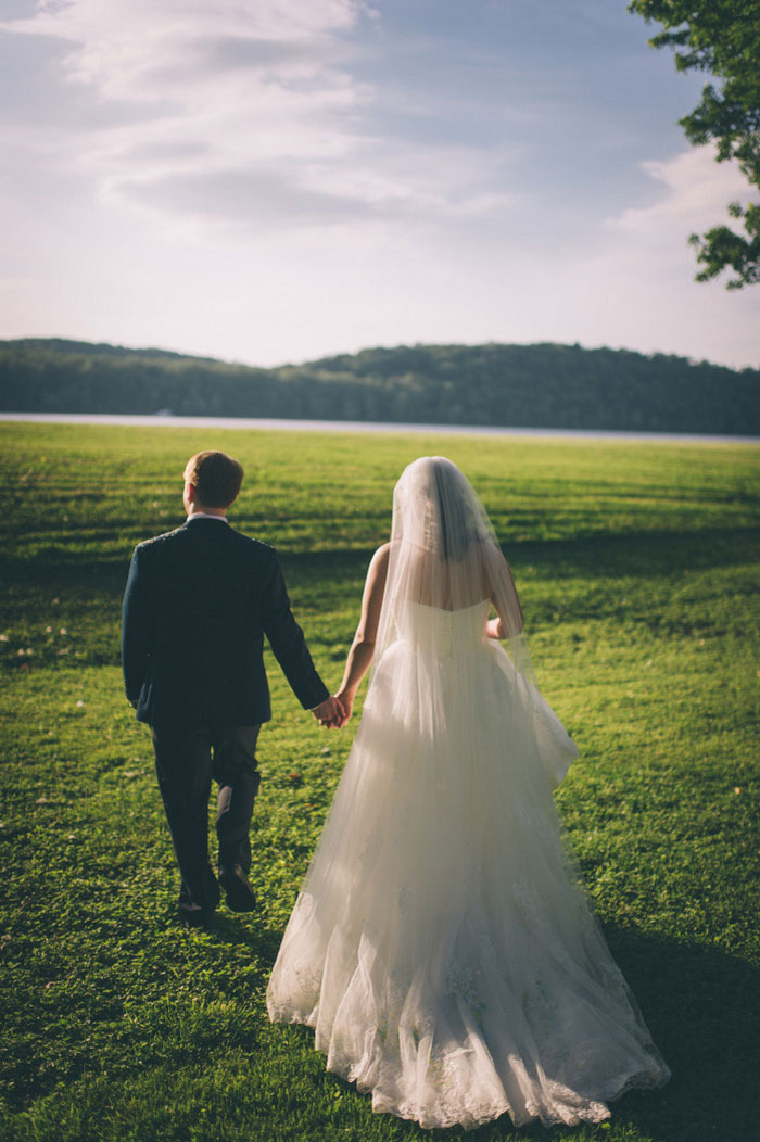 bride and groom walking into sunset