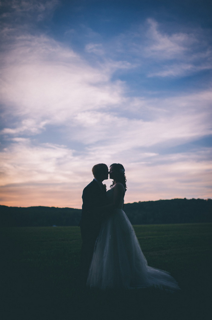 bride and groom kissing at dusk