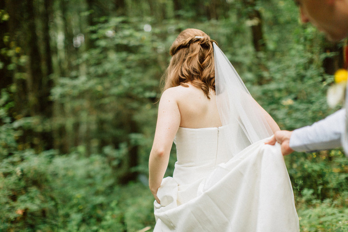 groom helping bride with her dress