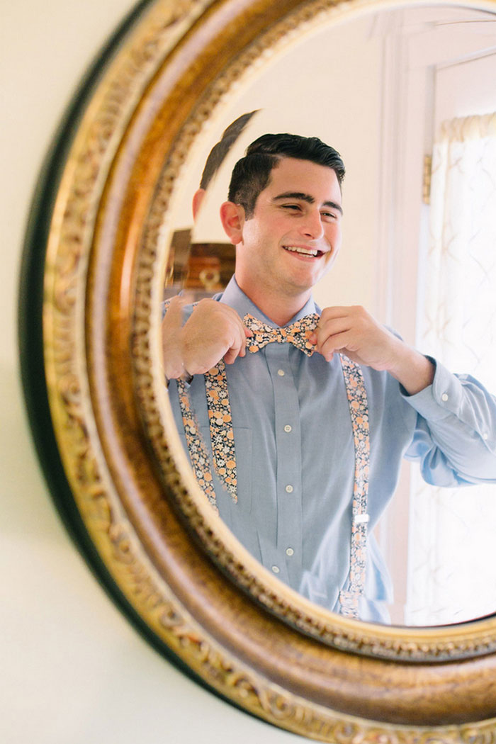 groom tying bow tie