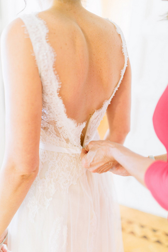 bride being zipped into her dress