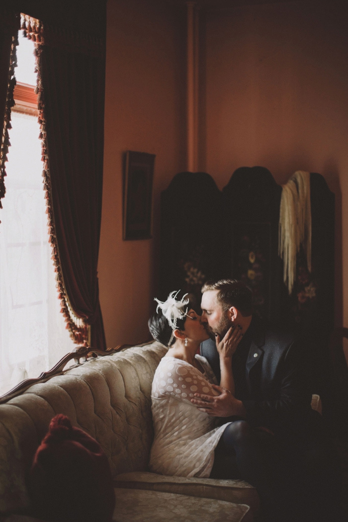 bride and groom kissing on the couch