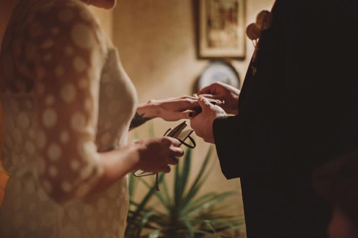 groom putting ring on bride's finger