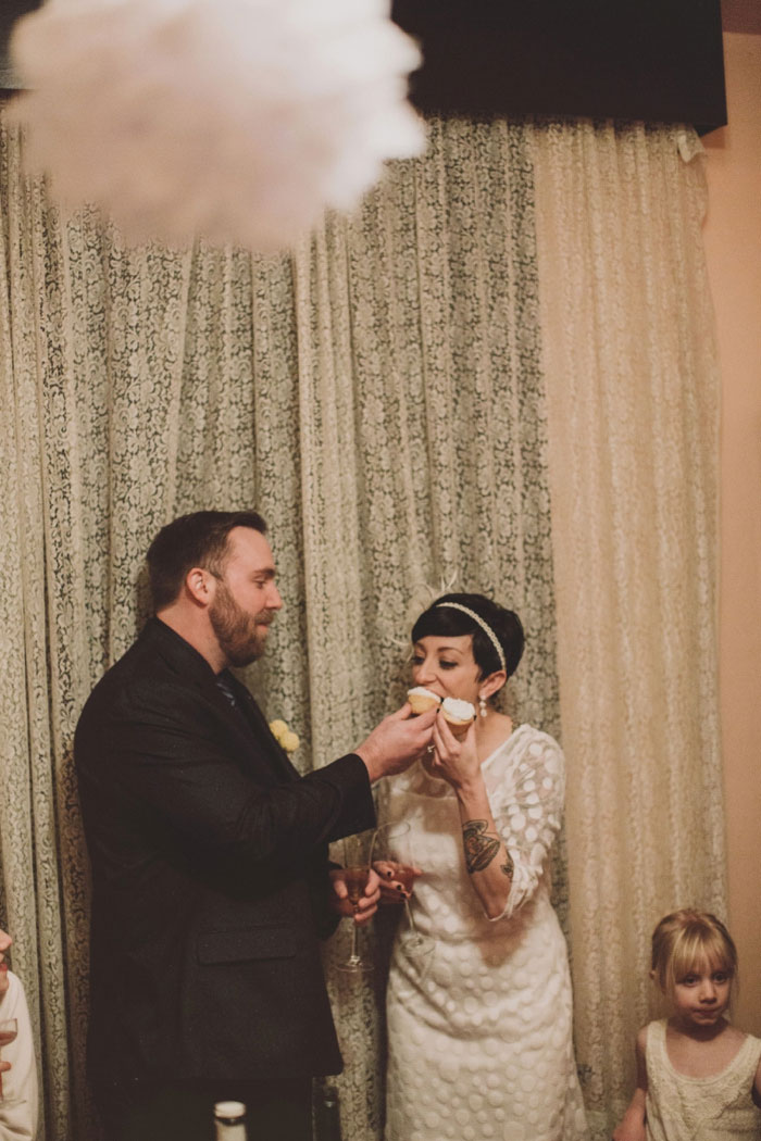 groom feeding bride a cupcake