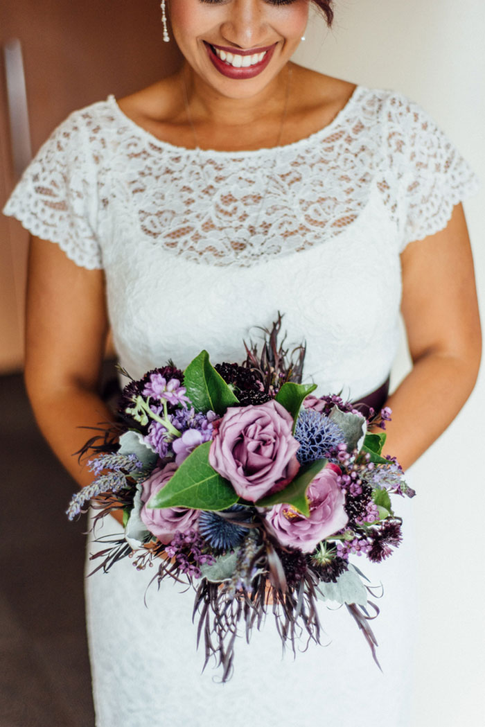 bride holding purple rose bouquet