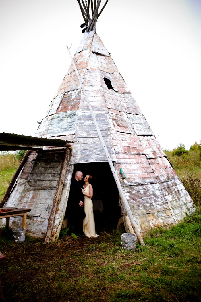 bride and groom portrait next to teepee