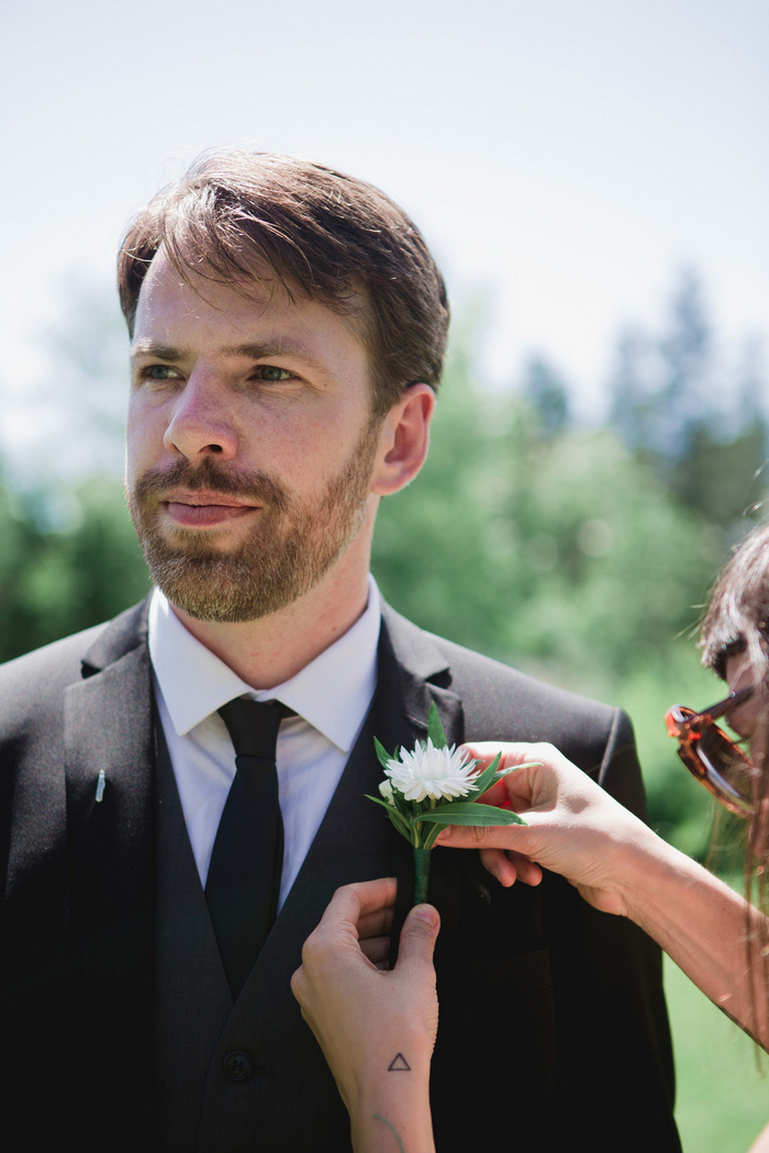 groom getting boutonniere pinned on