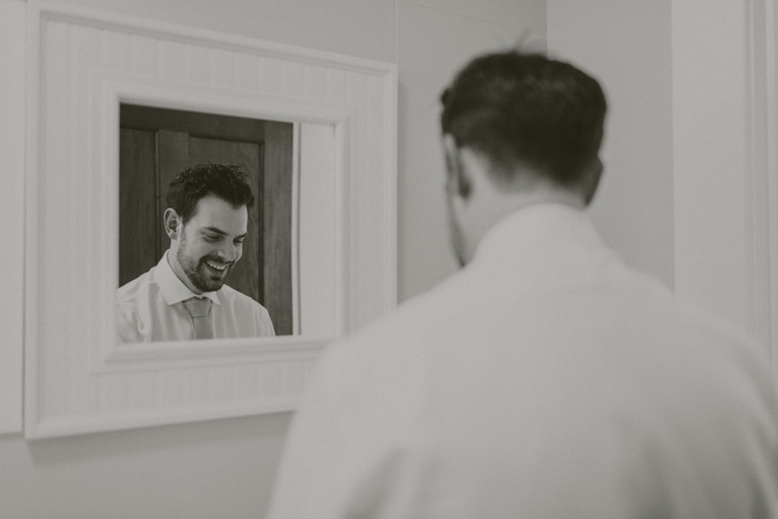 groom getting ready in the mirror