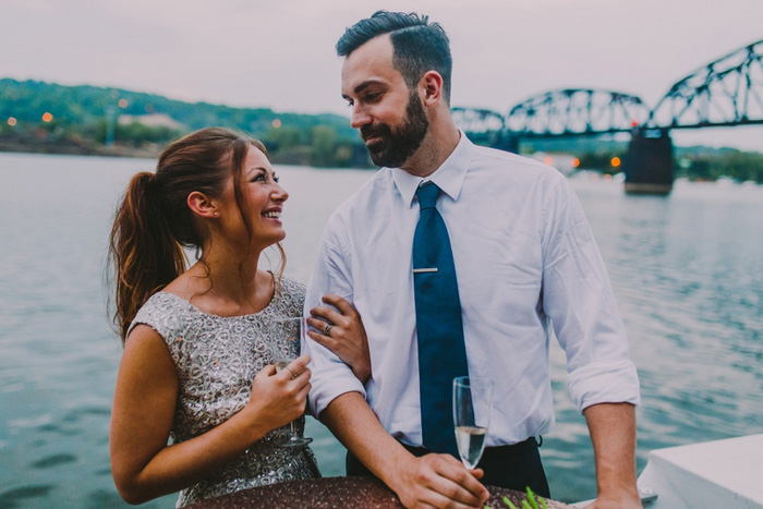 bride and groom by the water with champagne