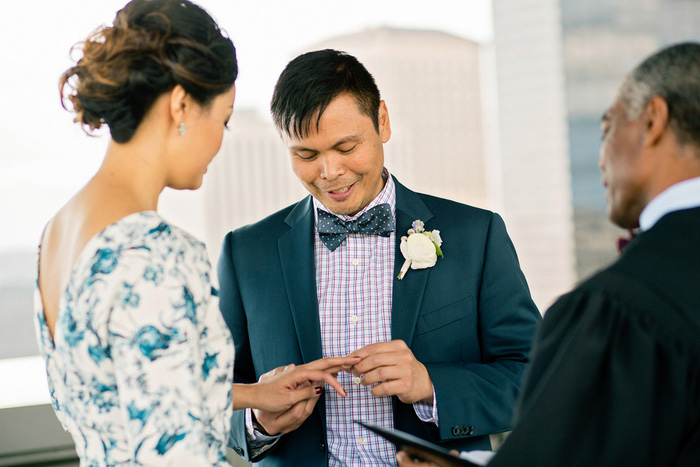 groom putting ring on bride's finger