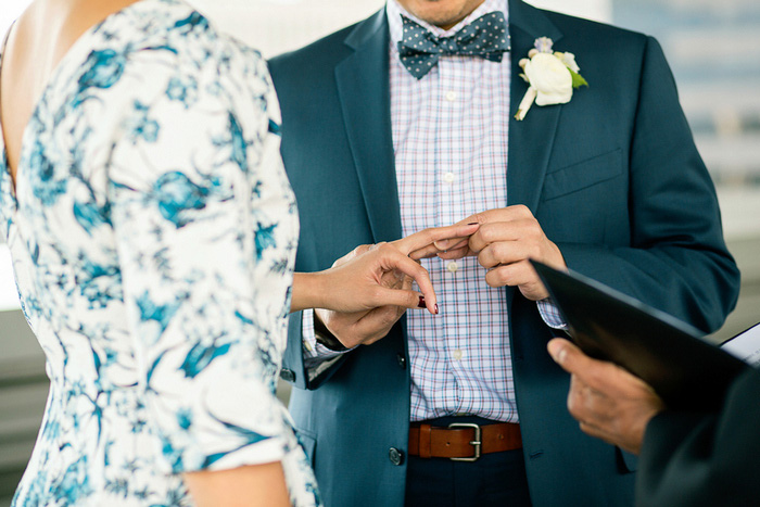 groom putting ring on bride's finger