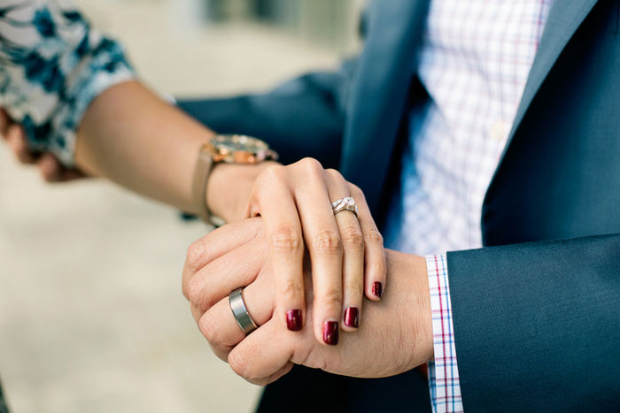 bride and groom wearing wedding rings