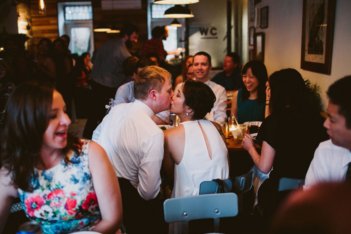 bride and groom kissing during dinner