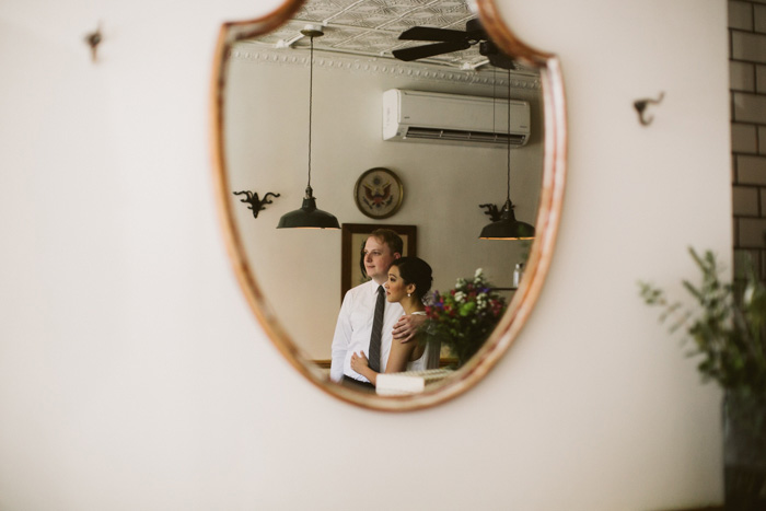 reflection of bride and groom in restaurant mirror