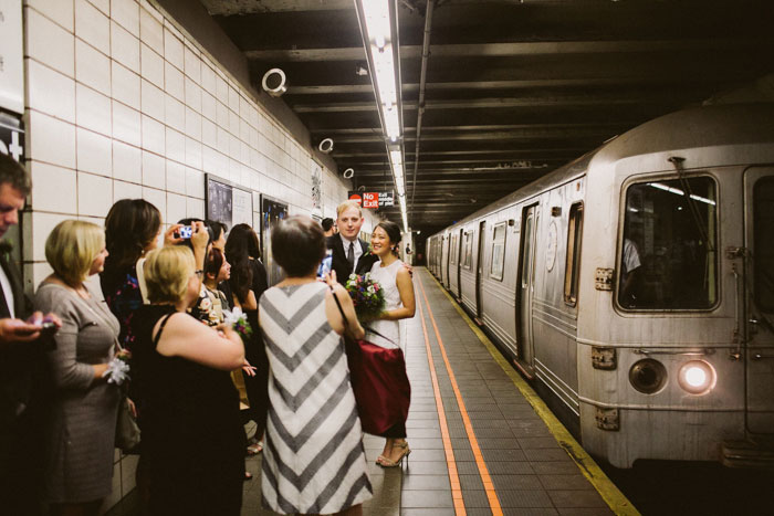 bride and groom on subway platform with family