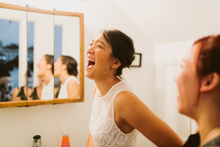 bride laughing while getting ready