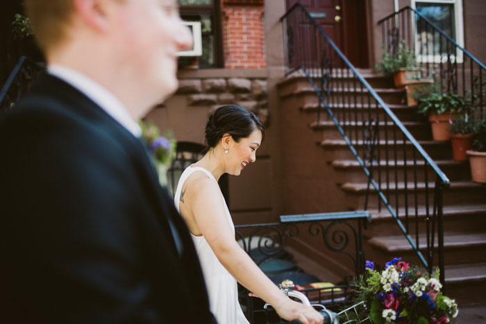 bride walking down street wheeling bike