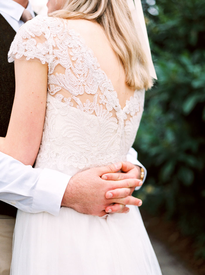 groom's hands clasped around bride's waist