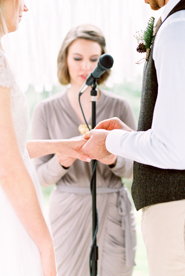 groom putting ring on bride's finger