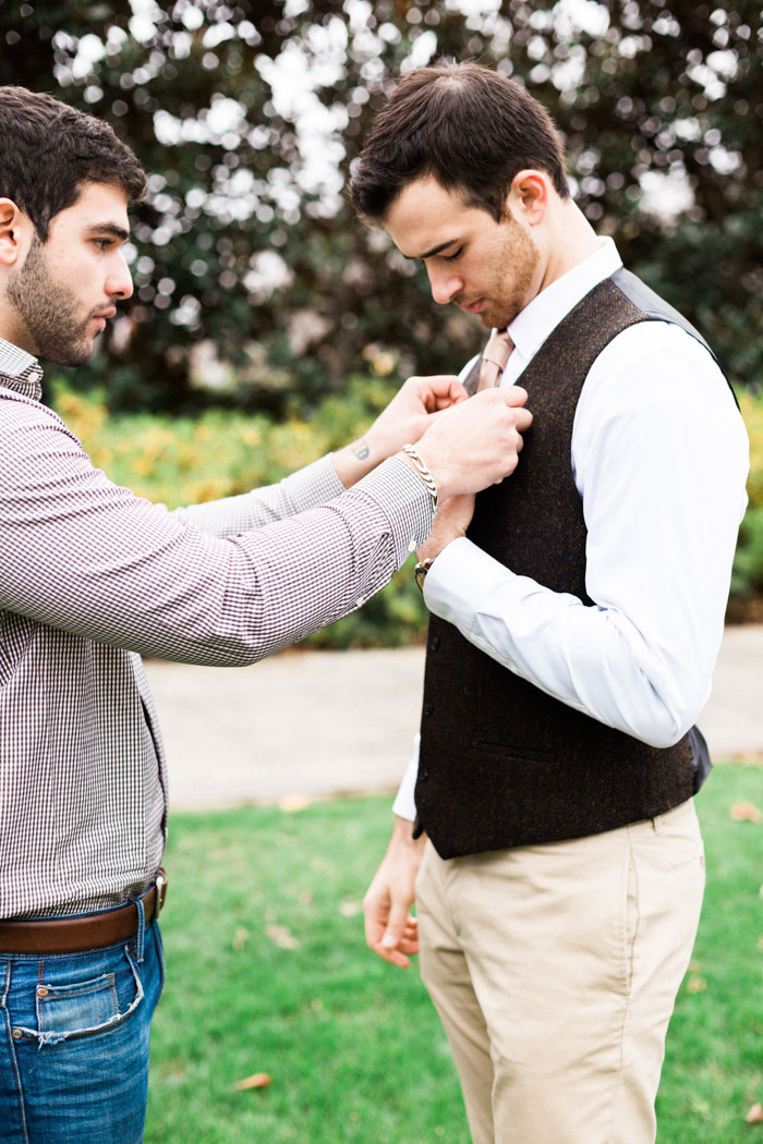 groomsman helping groom get ready