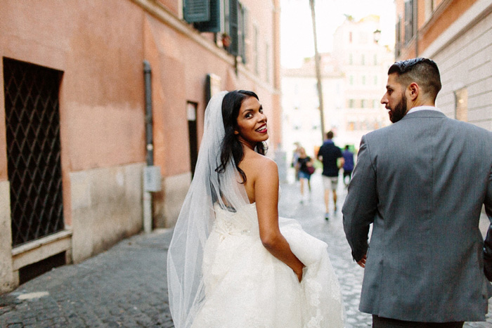 bride looking behind her shoulder as she walks down street