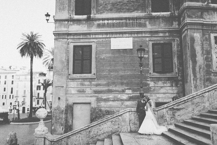 bride and groom kissing on steps in Rome