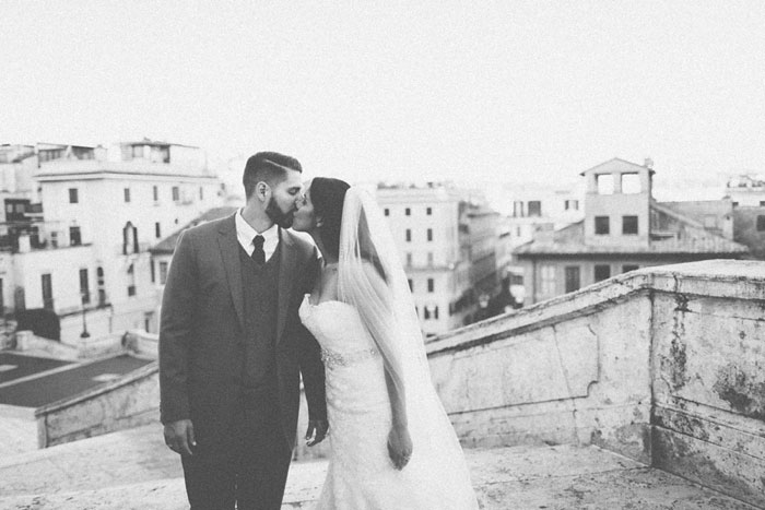 bride and groom kissing on steps in Rome