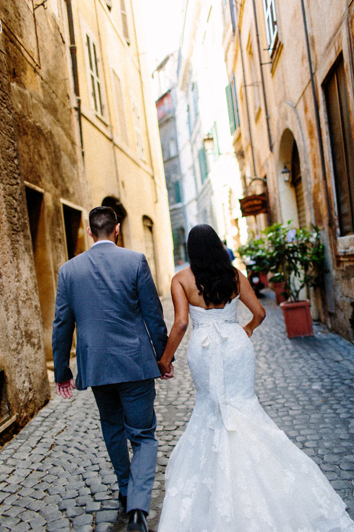 bride and groom walking down Roman alleyway